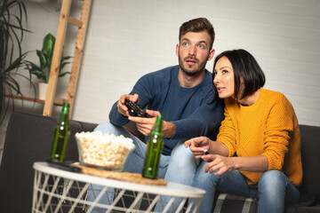 Young woman and man, couple or buddy friend gamers playing video games.
