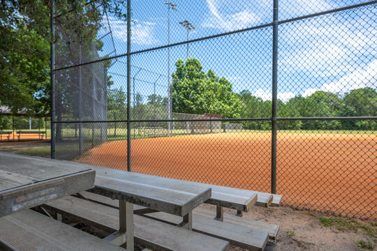 Bleachers overlook a well-maintained baseball field in a community park during a sunny afternoon