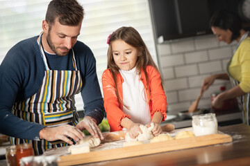 A child helps the father in the kitchen