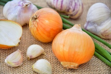 Yellow and green onions, garlic. Vitamins on the table.