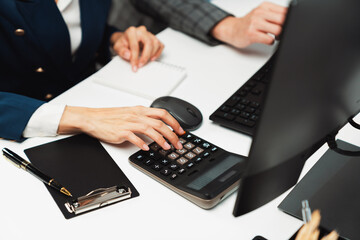 Cropped hands businessman with coworker calculating with calculator manual's financial and...