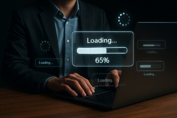 Man using laptop with loading screen showing progress bar at sixty five percent complete on the screen