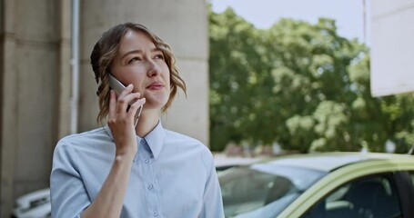 Engaged young woman converses on her smart phone outdoors, displaying a range of expressions from happy to pensive. She appears to be discussing educational plans or important academic matters.