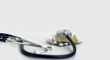 Stethoscope and pills on a white background