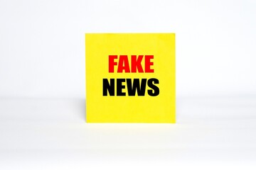 "FAKE NEWS" writing concept on sticky notes isolated on white background.