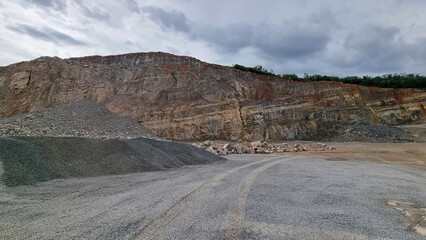 Gravel Quarry with Steep Rock Wall and Cloudy Sky