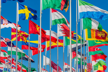 Lots of world's countries national flags waving on the wind, with Sweden, Sri Lankan, Macedonian, Tajik, Brazil, Sierra Leone, Bahrain banners in the foreground, Doha, Qatar