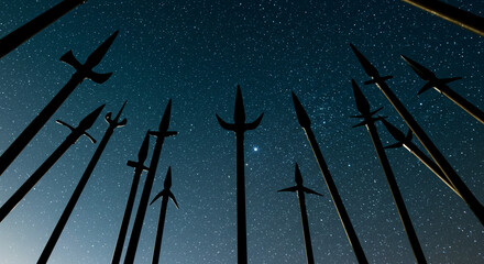 Ancient spears reaching for a starlit night sky, a silent testament to forgotten battles under a celestial canvas of shimmering darkness.