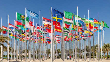 Fototapeta na wymiar Many world's countries national flags waving on the wind, with UN, EU, GCC, Sweden, Serbian banners in the foreground, Doha, Qatar