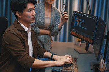 IT developers discussing with point to intelligent website development coder system running data...