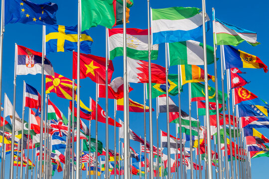 Lots of world's countries national flags waving on the wind, with Sweden, Serbian, Macedonian, Tajik, Bahrain, Nigerian Moldavian banners in the foreground, Doha, Qatar