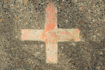 A cross is drawn on a cement surface