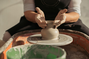 Potter creating clay vase on pottery wheel