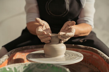 Potter creating clay vase on pottery wheel
