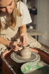 Potter creating vase on pottery wheel in workshop