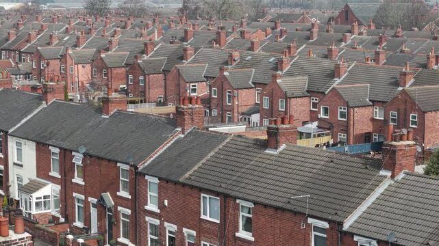 Aerial view above red brick terraced houses on council estate in England