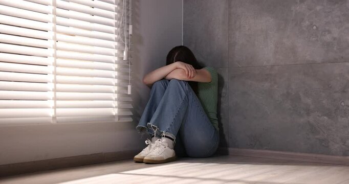 Woman suffering from paranoia near window indoors