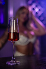 Fit blonde female wearing a two piece dress at a bar with a champagne glass