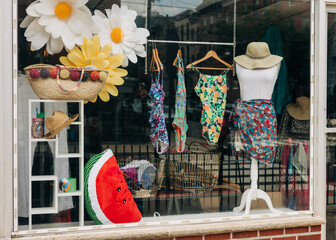 Colorful swimwear display in a boutique window on a sunny day near the beach