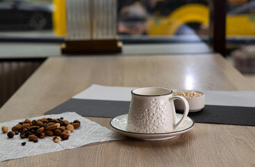 White beautiful handmade mug stands on light wooden table indoors