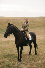 Equestrian Rider Sitting on a Black Horse in an Open Field