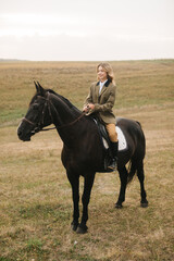Young Woman Riding Black Horse in a Scenic Countryside Landscape