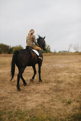 Horseback Rider on a Scenic Field Under a Cloudy Autumn Sky