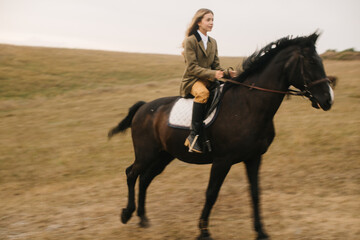 Fototapeta premium Woman Riding a Horse Across a Scenic Rural Landscape During Autumn