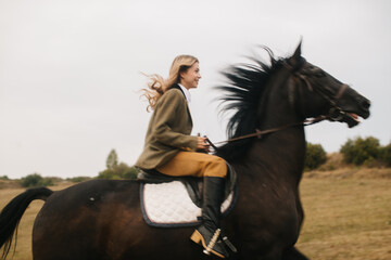 Young Woman Riding Freely on a Galloping Black Horse in Open Countryside