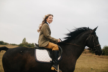 Young Woman Riding a Majestic Black Horse in a Scenic Countryside Field