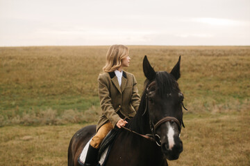 Stylish Woman Riding A Black Horse in an Open Countryside Landscape
