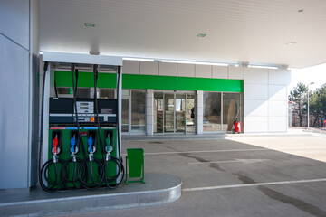 Modern, clean gas station with multiple fuel pumps and convenience store entrance, ideal for themes of travel, transportation, and energy infrastructure