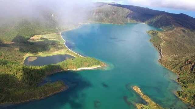 Azores Portugal 4K Drone. Cinematic flight through clouds breathtaking turquoise Lagoa do Fogo volcanic crater lake on Sao Miguel island. caldera mountain valley landscape b roll video