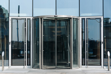 skyscraper in megalopolis with glass windows, central entrance with revolving door, business center...