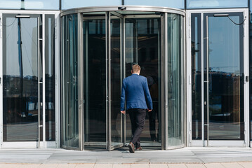 skyscraper in megalopolis with glass windows, business center in big city, central entrance with...