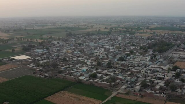 expansive farmland, showcasing vast green fields with scattered patches of agricultural plots