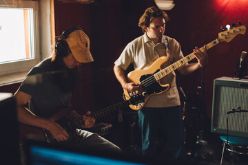Musicians playing guitars and bass in recording studio