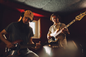 Obraz premium Musicians playing guitars and recording music in studio
