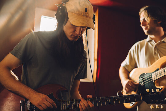 Musicians playing guitars and recording music in studio