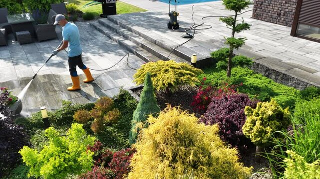 Gardener Uses Pressure Washer to Clean Patio and Maintain Garden