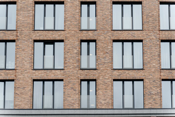 modern multi-storey apartment building, brown brick building with glass windows, urban background