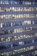 Modern office building facade with glass windows in Cologne city at night.