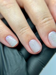 Clean natural manicure on female hand in black glove closeup. Closeup of a woman's hand with short...