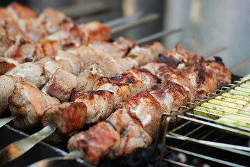 Grilled kebab being cooked over a fire on a metal skewer. Roasted meat cooked at barbecue. BBQ fresh beef meat chop slices. Shish kebab on skewer. Meat cooked over fire