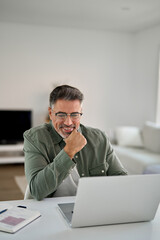 Hybrid work, elearning, online learning. Happy smiling middle aged older mature man wearing glasses...
