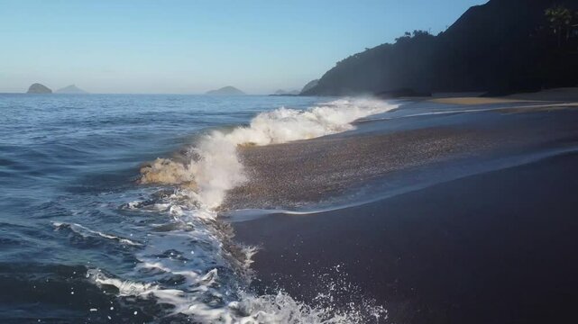 Amazing short wave breaking on a beach with silver sea