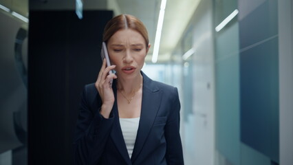Angry businesswoman arguing cellphone at corridor closeup. Lady scolding online