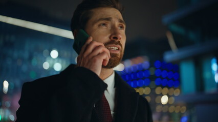Disappointed boss complaining mobile phone call at night city view portrait