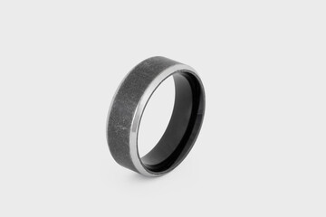 Black stainless steel finger ring isolated on a white background with bokeh