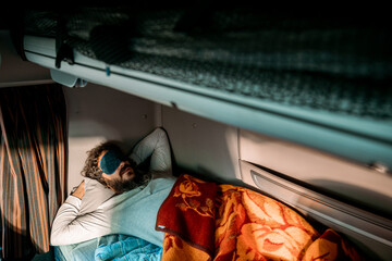 Truck driver sleeping in sleeper cab with eye mask